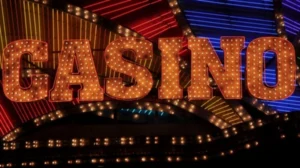 A close-up of a vintage neon 'CASINO' sign at night, glowing with warm marquee lights against a colorful background of neon streaks.